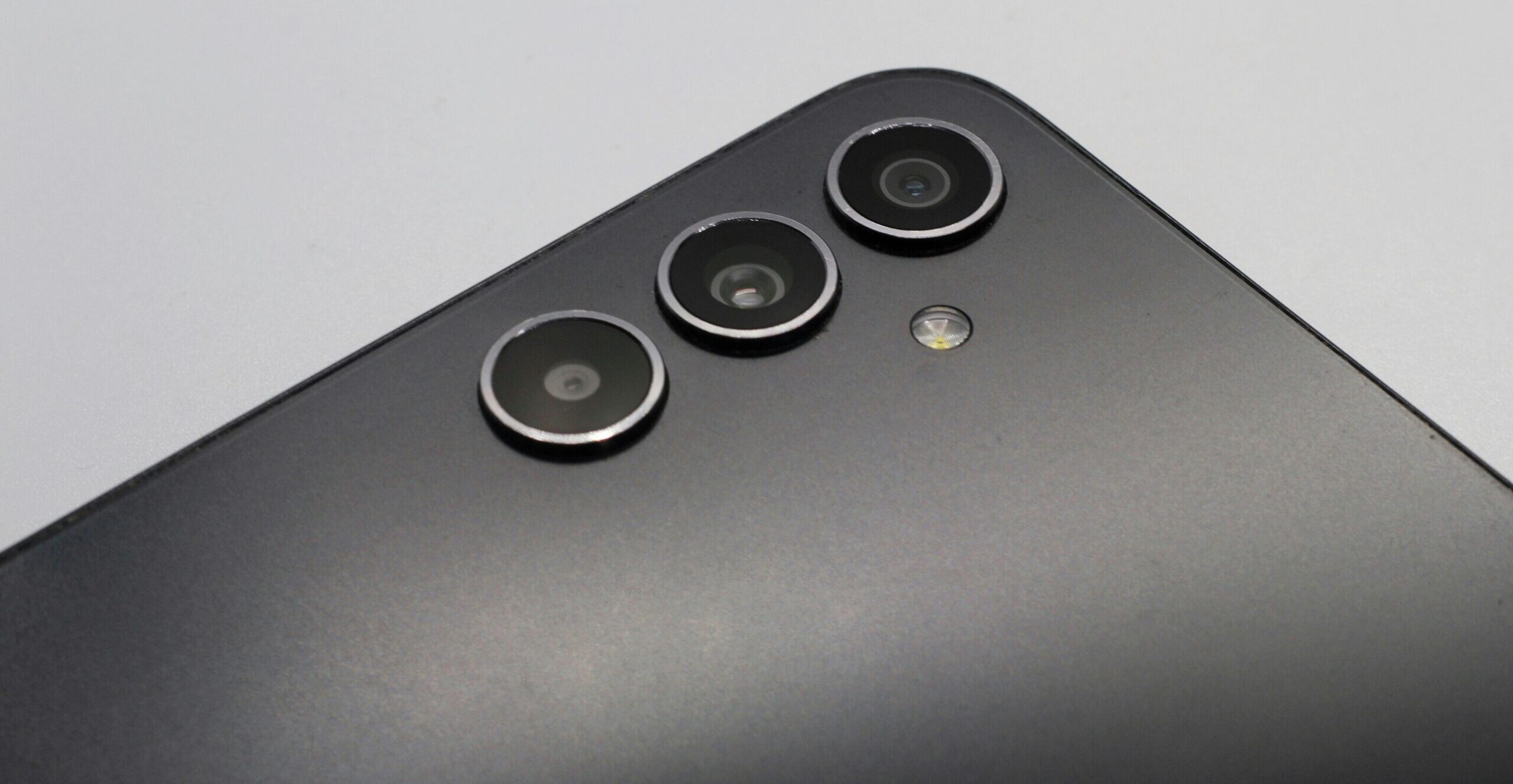 Close-up of a sleek smartphone with triple camera lenses and matte finish.
